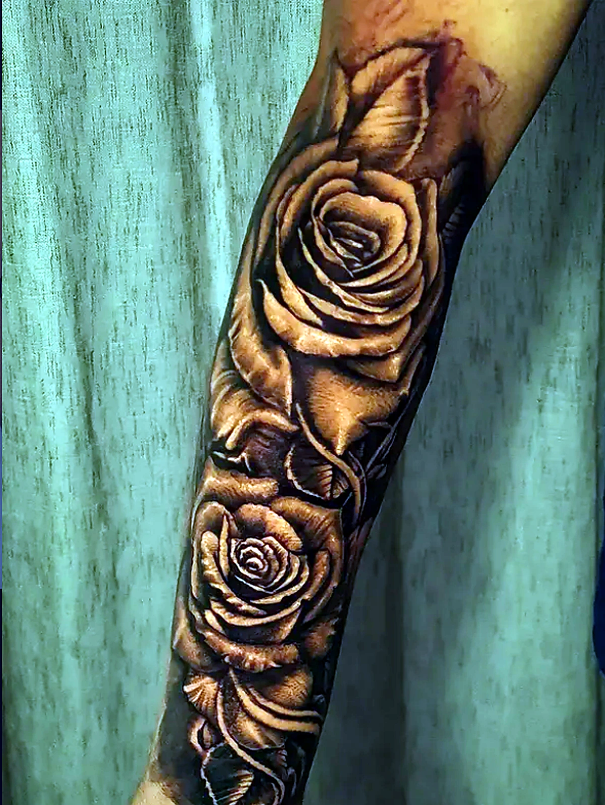 Tatuagem realista de rosas no braço