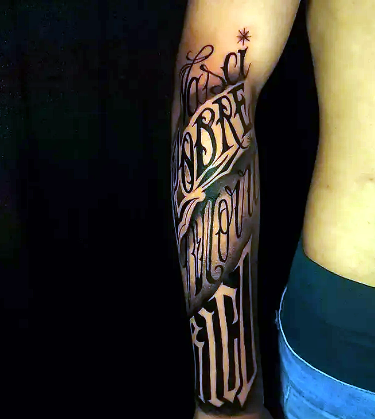 Tatuagem lettering em preto no antebraço