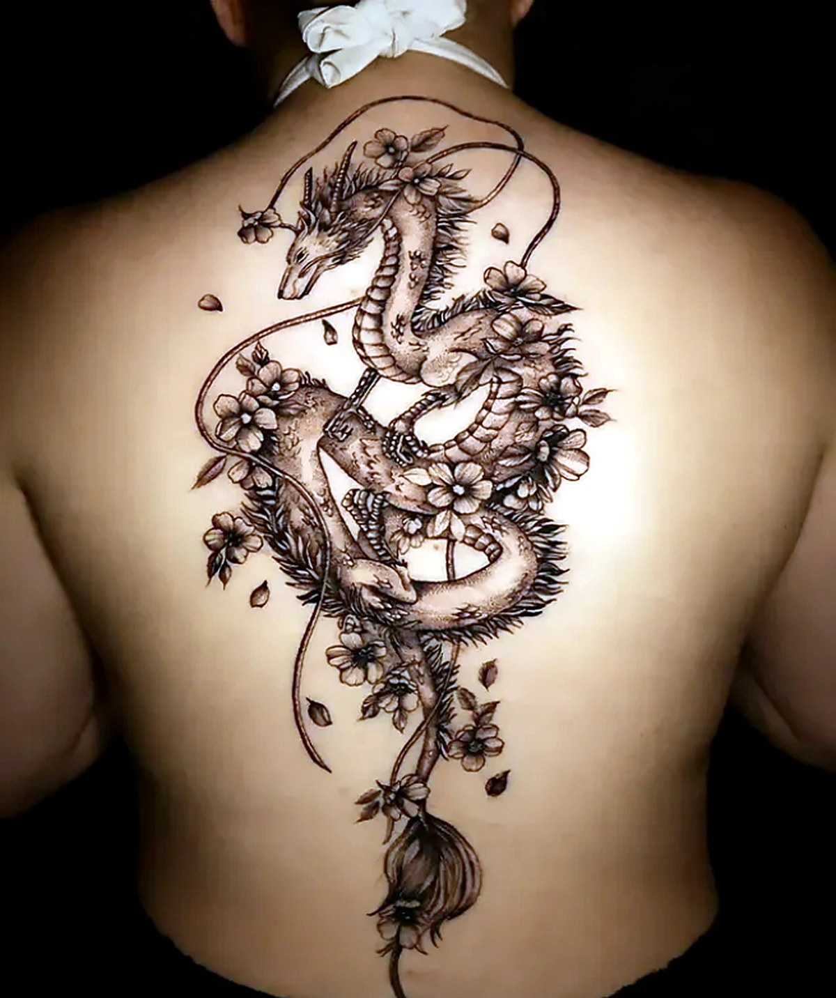 Tatuagem oriental de dragão e flores nas costas