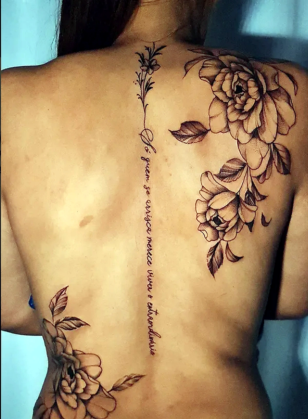 Tatuagem floral com escrita nas costas