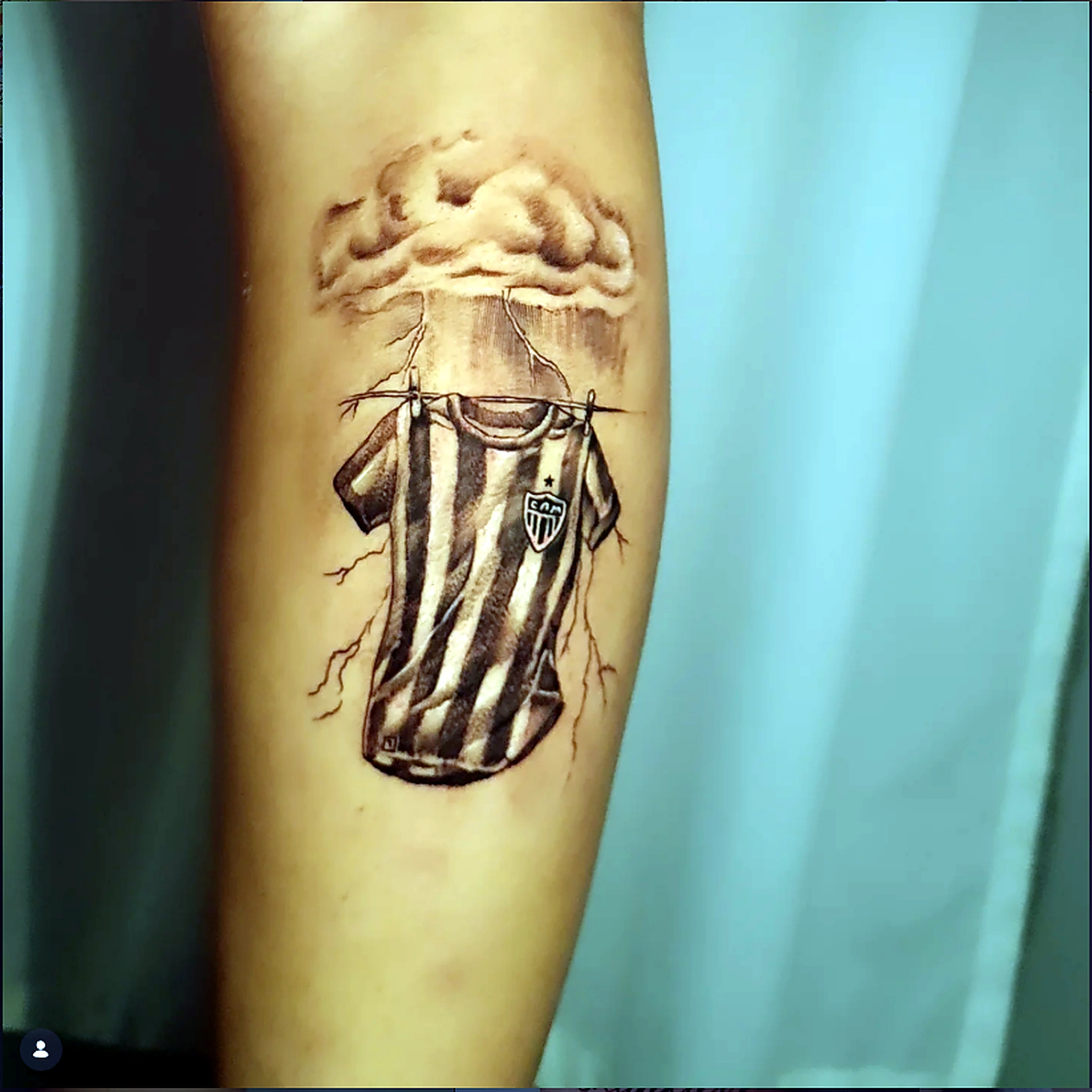 Tatuagem da camisa do Atlético Mineiro com nuvens e raízes